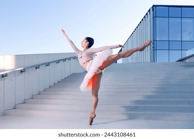 Sexy Sensual Slim Professional Caucasian Ballet Dancer in Rose Pink Tutu Dreass Whie Posing In Dance Flying Pose On Blue Stairs In Stretched Pose Outdoor.Horizontal Image