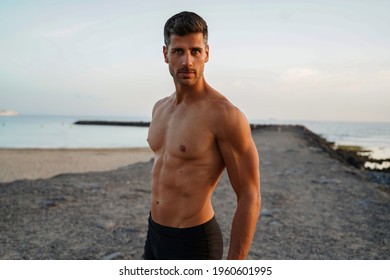 Sexy shirtless young italian man with muscular body posing outdoors shirtless.                             