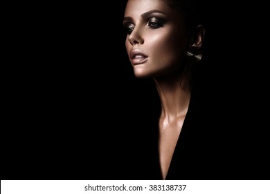 The Sexy Strict Woman With Makeup And A Fashionable  Hairstyle Poses In Studio On Black Background