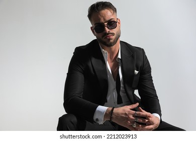 Sexy Stylish Guy With Open Collar Shirt Holding Hands And Posing In Front Of Grey Background In Studio