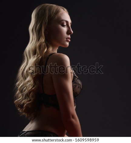 Sexy underwear model posing while sitting on bed