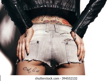 Sexy woman body with tattoo in jeans shorts. The model is back. Great ass. White background not isolated