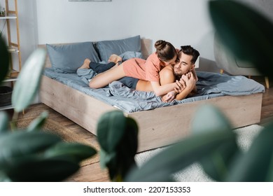 Sexy Woman Embracing Shirtless Boyfriend Lying On Bed On Blurred Foreground