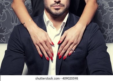 Sexy woman hands with red nails embrace rich man