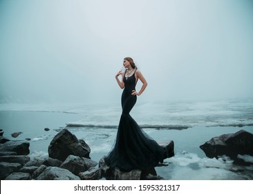 Sexy Woman Long Black Dress Silhouette Mermaid Tail Fish. Background River Ice Water Stones Cold Snow. Winter Frozen Lake. Dark Gothic Queen. Fashion Design Creative Decoration Necklace Collar Beads