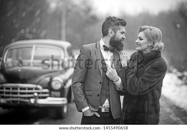 sexy woman\
in luxury fashion coat and man driver. sexy woman with stylish hair\
and makeup at driver in retro\
car