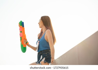 Sexy Woman On Blue Tank Top Vest Shirt With Watergun. Songkran Festival In Bangkok, Thailand.