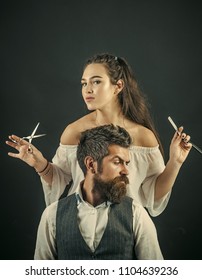 Sexy Woman. Oung Couple Of Pretty Hairdresser Combing And Cut Male Brunette Hair Of Handsome Bearded Man With Long Beard In White Shirt On Grey Background