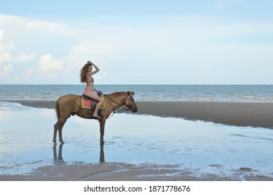 Sexy Woman In Pink Bikini Riding Horse On The Beach Over Sea And Sky, Business Summer Holiday And Travel Concept