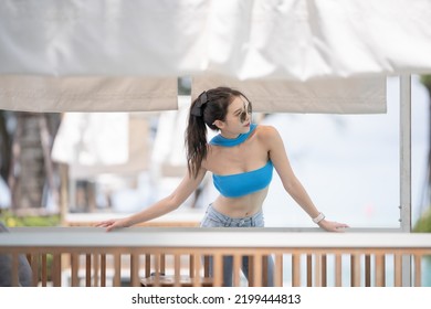 Sexy Woman Relaxing Near Sunbed Cabana By The Pool At Hotel Resort.