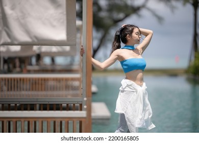 Sexy Woman Relaxing Near Sunbed Cabana By The Pool At Hotel Resort.