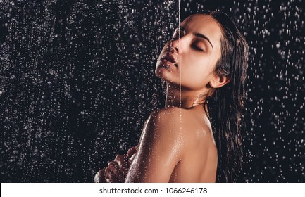 Sexy Woman In Shower. Attractive Young Naked Woman Under Water Drops Isolated On Black Background.