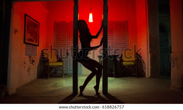 Sexy Woman Silhouette Dancing at the Hotel.
Pole Dancer female Stripper in the Night Sensual Red light, noir
style. Beautiful Dancing Girl with Sexy Body. Romantic Hot Erotic
Private dance, striptease