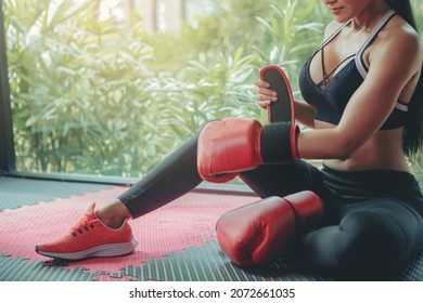 Sexy woman tying tape around her hand before get boxing gloves preparing to boxing practice.