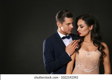 Sexy woman in underwear and businessman wearing suit on dark background
