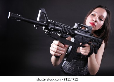 Sexy women - Girl holding an Assault Rifle, black background