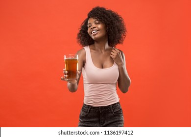 Sexy Young African American Woman Drinking Beer Over Orange Studio Background