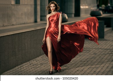 Sexy young beauty woman in fluttering red dress