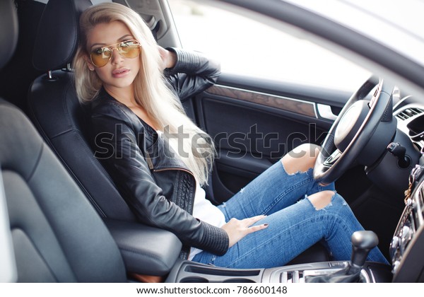 車に乗ったセクシーな金髪の女性 高級車 車の中に座っているかわいい女の子 ファッションとスタイル の写真素材 今すぐ編集