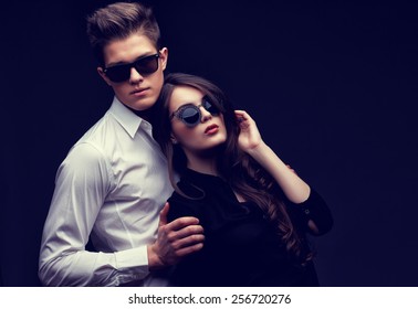 Sexy young couple in love. Studio shot on dark background