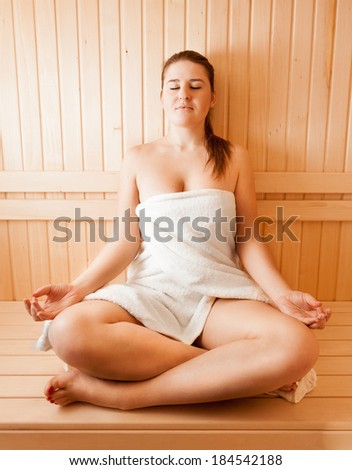 Sexy Young Naked Woman In Towel Meditating At Sauna Sexy Young Naked Woman In Towel Meditating At Sauna