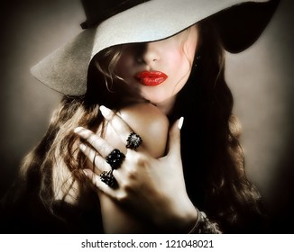 Sexy young pretty woman / model with red lips, vintage / retro hat and jewelry is sending a kiss / smooch - closeup