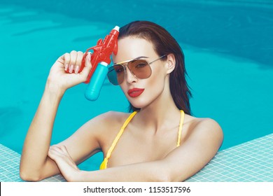 Sexy Young Spy Woman Holding Water Gun In Swimming Pool, Retro Style