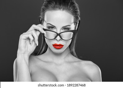 Sexy young woman looking while taking off eyeglasses, black and white with red, selective coloring