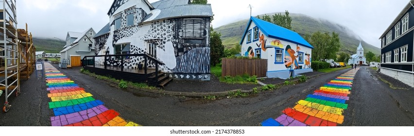 Seydisfjordur, Iceland - 23.June 2022: The Famous Rainbow Road In Seydisfjordur With Icelandic Buildings Around Show Artwork Painted Walls