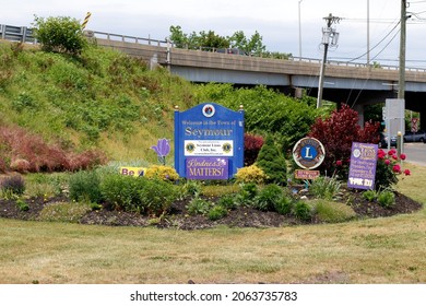 Seymour, CT, USA - May 28, 2021: Welcome to the Town of Seymour sign along with other local signs during the day. Town of Seymour welcome sign with flowers and foliage at the end of an exit ramp.