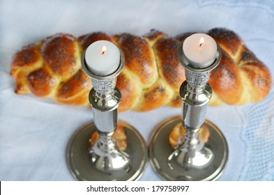 Shabbat Candle-Lighting with uncovered challah bread. Jewish lifestyle background. No people. Copy space