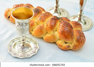 Shabbat Eve Table With Uncovered Challah Bread, Sabbath Candles And Kiddush Wine Cup.