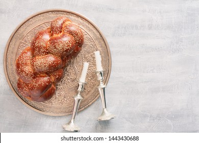 Shabbat or Sabbath kiddush ceremony composition with a traditional sweet fresh loaf of challah bread, vintage background with copy space. Overhead view, top view or above view comoisition