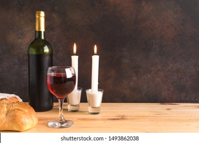 Shabbat or Shabath concept. Challah bread, shabbat wine and candles, copy space. Traditional Jewish Shabbat ritual. Shabbat Shalom.