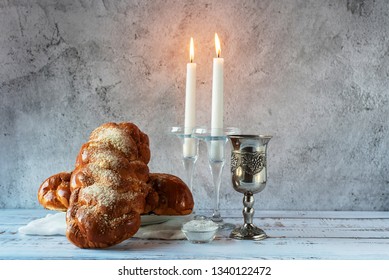 Shabbat Shalom - challah bread, shabbat wine and candles on wooden table.