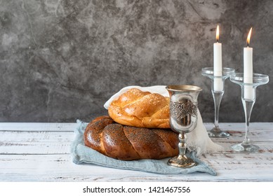 Shabbat Shalom - challah bread, shabbat wine and candles on grey background. With copy space.