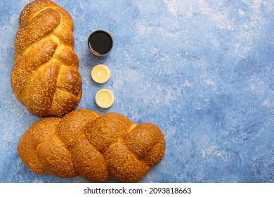 Shabbat Shalom challah bread, shabbat wine and candles on table. Blue background. Top view. Copy space.