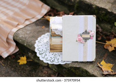 Shabby Chic Decor And Fallen Autumn Leaves. White Vintage Book With Place For Text On Stone Steps.