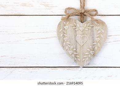 Shabby chic heart shaped ornament on a jute twine with a bow against white wooden background with copy space - Powered by Shutterstock