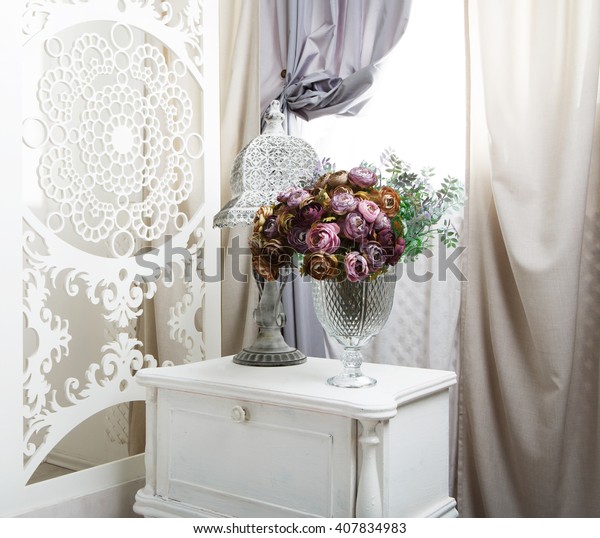shabby chic room interior. Wedding decor, room\
decorated for shabby chic rustic wedding, with bedside table,\
folding screen or room divider with white tracery and rose\
bouquets. High key,\
closeup