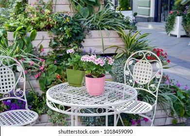 Shabby Chic Summer Exterior Decoration With Flowers And White Garden Furniture