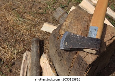 Shabby Cleaver-ax And Chipped Firewood By The Oak Stump On The Grass In The Courtyard Top View. Rest After Hard Manual Work