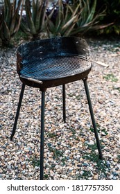 Shabby Metal Grill Located On Blurred Background Of Backyard On Summer Day In Countryside