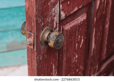 shabby round handle of an old burgundy peeling door background and texture - Shutterstock ID 2276863015