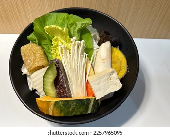 Shabu shabu is a Japanese food type of Nabemono in the form of very thin slices of beef dipped in a special pot filled with hot water on the dining table. - Shutterstock ID 2257965095