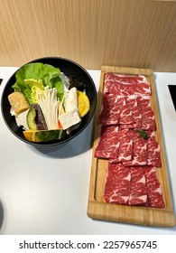 Shabu shabu is a Japanese food type of Nabemono in the form of very thin slices of beef dipped in a special pot filled with hot water on the dining table. - Shutterstock ID 2257965745
