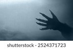 Shade of werewolf hands with fur and black claws on a blue background. The hand is reaching out, and the shadow is dark. Scary claw of werewolf, wolfman, or animal monster. Spooky Halloween concept