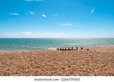 Shades of blue. A day in the british south coast, in Felpham, near brighton. View of the beach of pebbles or rocks ,bright blue sea and sky, sunny day. Beautiful summer day in Britain. - Powered by Shutterstock