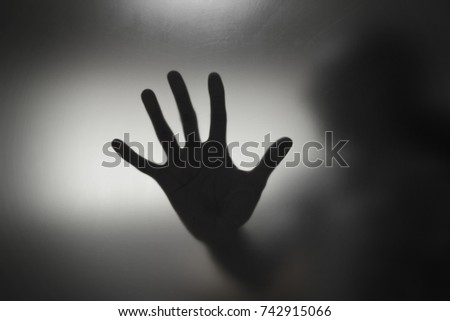 Shadow blur hands of the Man behind glass thiller them
