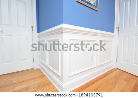 Shadow boxes, wainscoting painted bright white with hardwood floor
